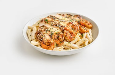 Image of Chicken and Shrimp Pasta with penne noodles and cream sauce.